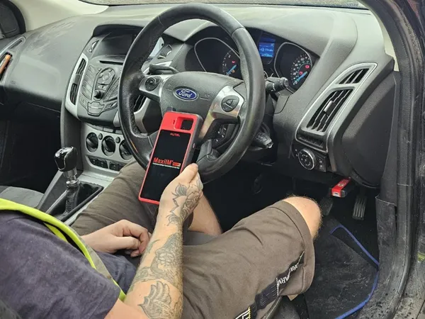 Mobile auto locksmith using diagnostic equipment for a Ford key job in Hereford